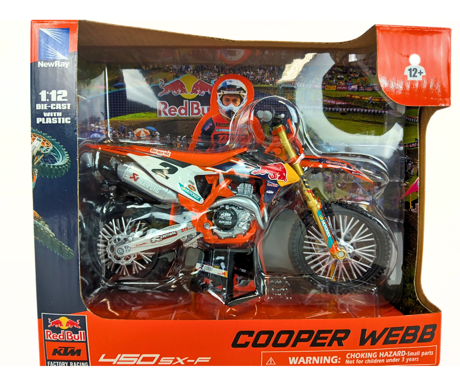 Model dirt bike in packaging with Cooper Webb branding and Red Bull logo.