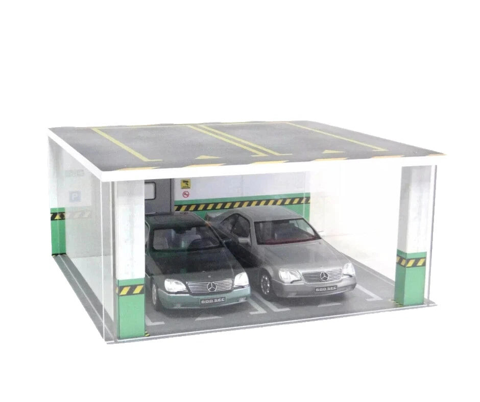Model of a car garage with two cars inside on a white background