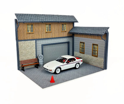 Model of a house with a car parked in front on a white background