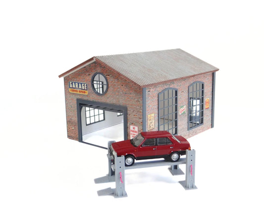 Model of a brick building with an open garage door and a red car inside on a white background
