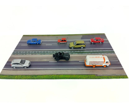 Model cars on a miniature road with a white background