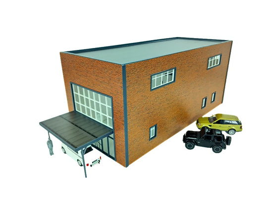 Model of a brick building with toy cars in front on a white background