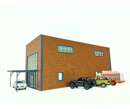 Model of a brick building with cars and a truck in front on a white background