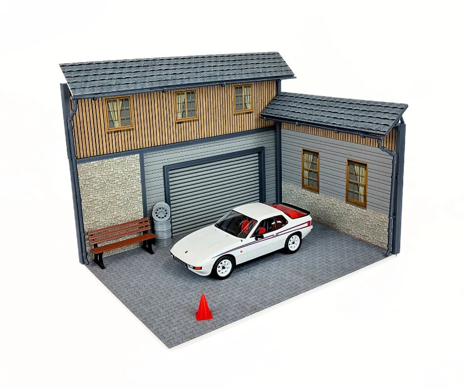 Model garage with a car parked inside on a white background