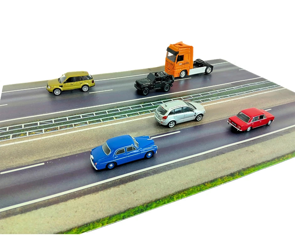 Model cars on a miniature road with different vehicles including a truck and cars.